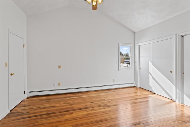 unfurnished bedroom with vaulted ceiling, wood-type flooring, and a baseboard radiator