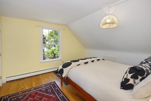bedroom with baseboard heating, wood finished floors, and lofted ceiling