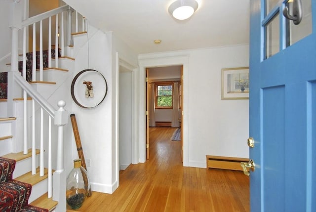 entrance foyer with baseboards, a baseboard heating unit, stairway, and wood finished floors