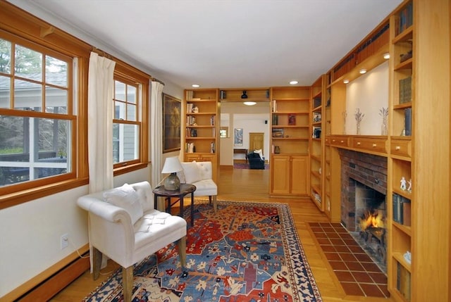 sitting room with built in features, baseboard heating, a brick fireplace, wood finished floors, and recessed lighting