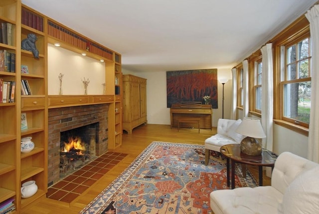 living room featuring a brick fireplace and wood finished floors
