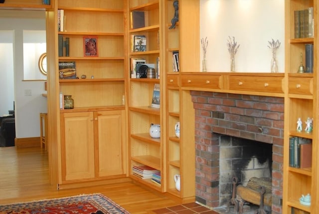 details with a brick fireplace and wood finished floors