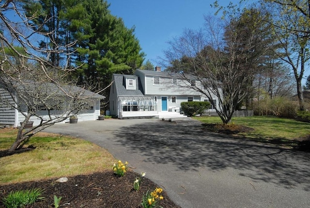 view of front of home with a chimney and aphalt driveway