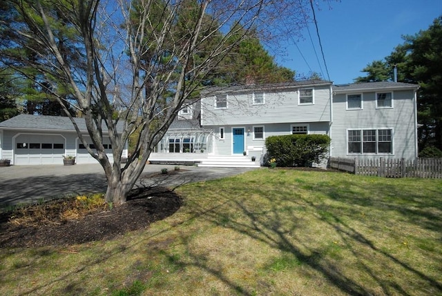view of front of home with a garage, fence, and a front yard