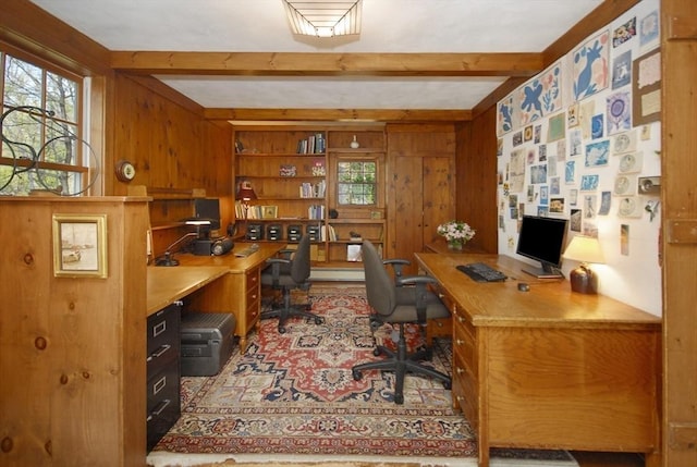 office featuring built in study area, wood walls, and beamed ceiling