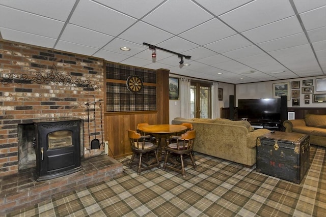 198 Mountain View Dr, Holyoke, MA 01040 - living area with a wood stove, carpet, a paneled ceiling, and wood walls