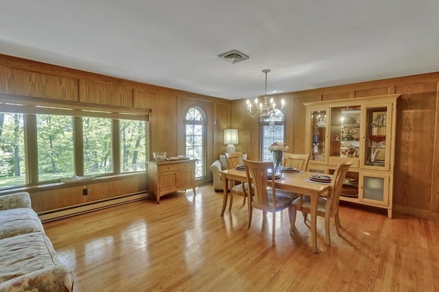 198 Mountain View Dr, Holyoke, MA 01040 - dining space with a baseboard radiator, a chandelier, wood walls, and light wood-type flooring