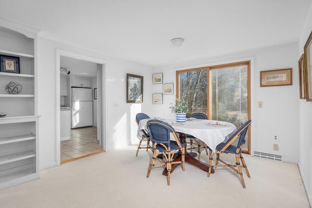 carpeted dining space with tile patterned flooring and visible vents