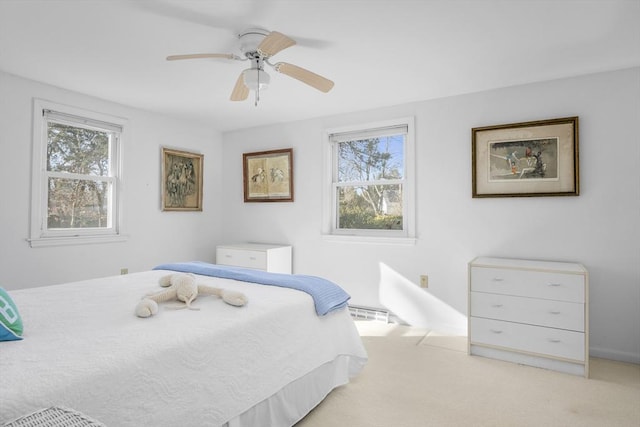 bedroom with light carpet, ceiling fan, and multiple windows