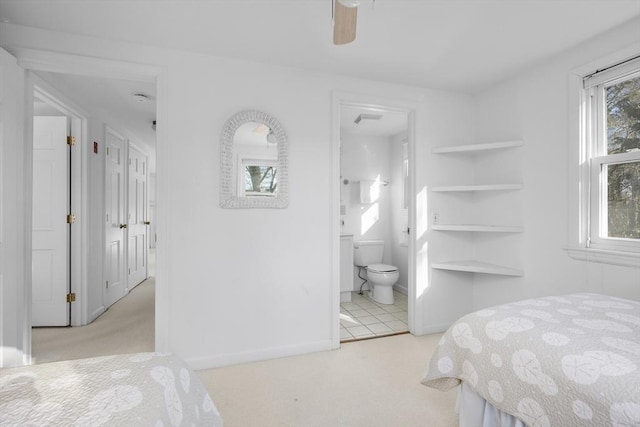 bedroom featuring carpet floors, ceiling fan, baseboards, and ensuite bathroom