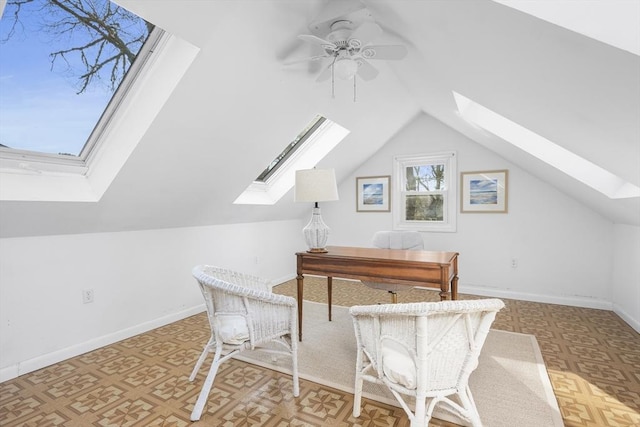 office with lofted ceiling with skylight, ceiling fan, and baseboards