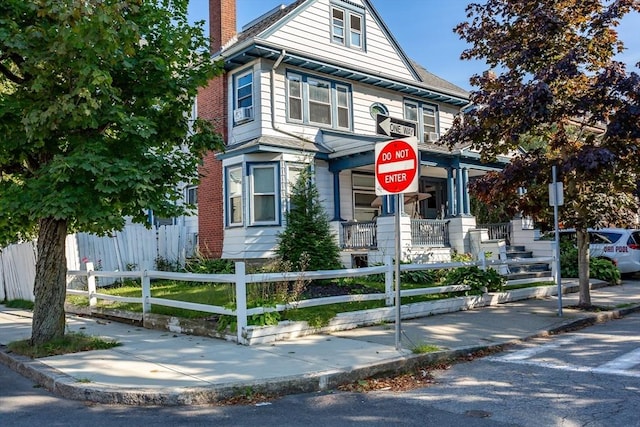 american foursquare style home with a fenced front yard and a chimney