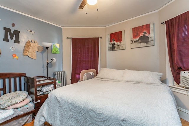 bedroom with crown molding, ceiling fan, radiator, and hardwood / wood-style flooring