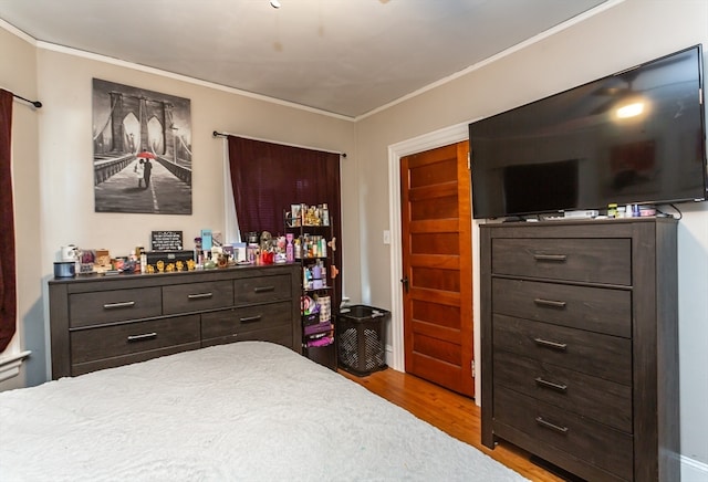 bedroom featuring crown molding and light hardwood / wood-style flooring