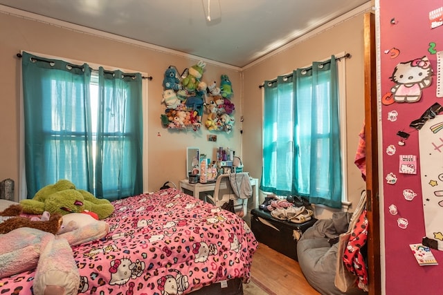 bedroom with multiple windows, ceiling fan, hardwood / wood-style floors, and ornamental molding