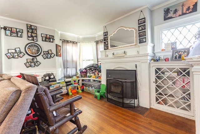 living room with crown molding, hardwood / wood-style floors, and a wood stove