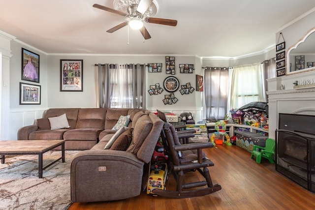 living room with crown molding, dark wood-type flooring, and ceiling fan