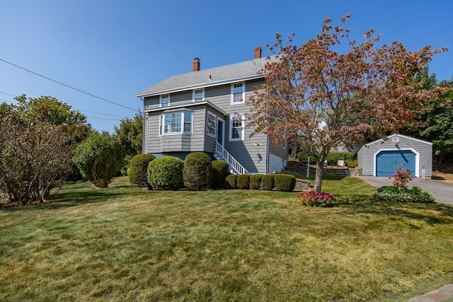 view of front of house with a front lawn, an outdoor structure, and a garage