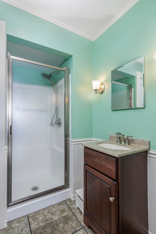 bathroom with a shower with door, vanity, and crown molding