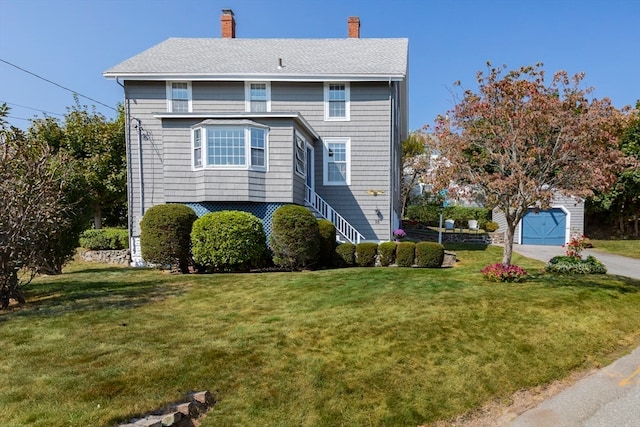 view of front facade featuring a front yard, an outbuilding, and a garage