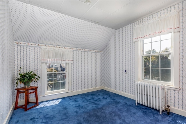 bonus room featuring radiator, dark colored carpet, and vaulted ceiling