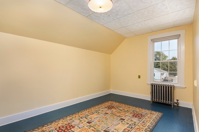 bonus room with radiator, lofted ceiling, and dark colored carpet