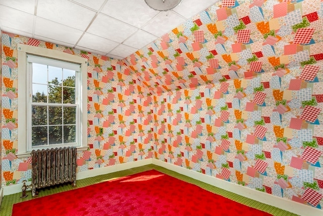 playroom featuring radiator heating unit, a drop ceiling, and carpet flooring