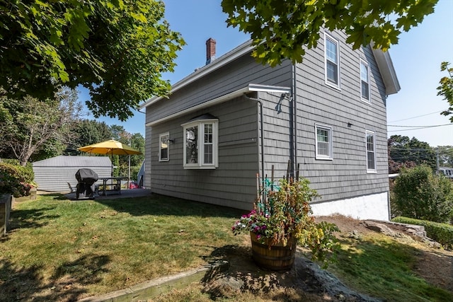 view of property exterior with a lawn and a patio