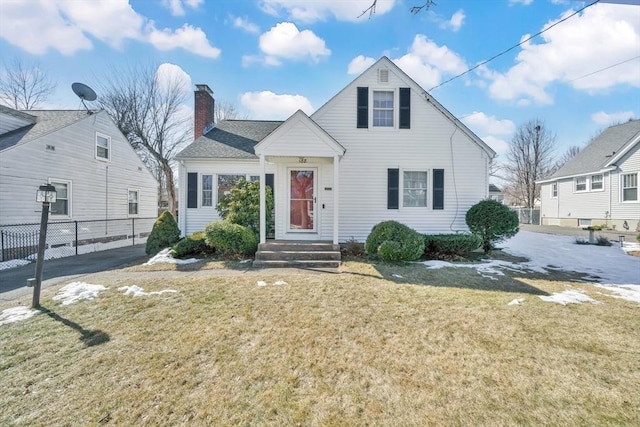 view of front of property featuring a chimney, a front lawn, and fence