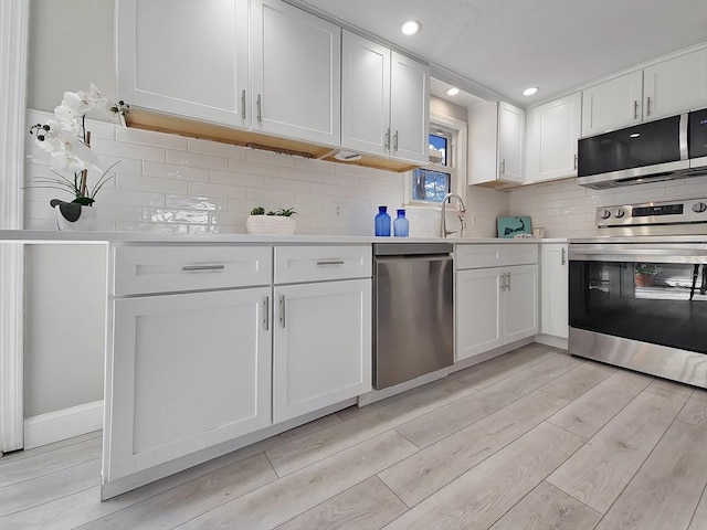 11 Great Oak Rd, Brewster, MA 02631 - kitchen featuring white cabinetry, light countertops, stainless steel appliances, and light wood-style flooring