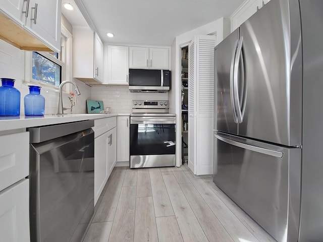11 Great Oak Rd, Brewster, MA 02631 - kitchen featuring light countertops, white cabinets, appliances with stainless steel finishes, a sink, and light wood-type flooring