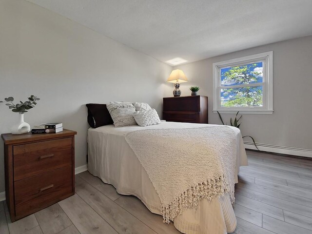 11 Great Oak Rd, Brewster, MA 02631 - bedroom with lofted ceiling, light wood-style flooring, and a baseboard heating unit