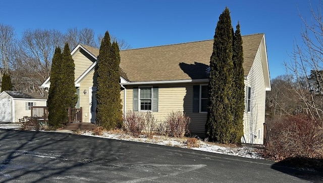 view of side of home featuring a shed