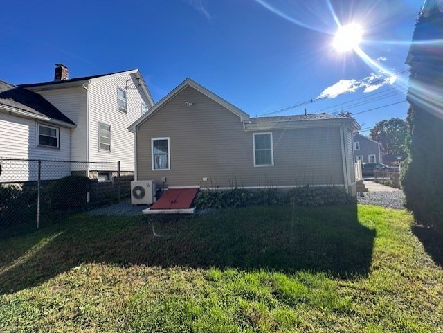 back of house with a yard and ac unit