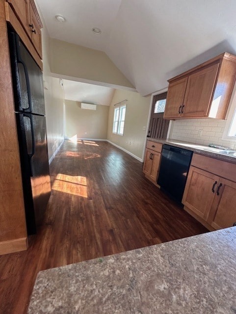 kitchen with black appliances, vaulted ceiling, dark wood-type flooring, and tasteful backsplash