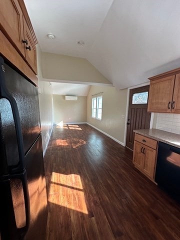 kitchen featuring dark wood-type flooring, tasteful backsplash, an AC wall unit, vaulted ceiling, and black appliances