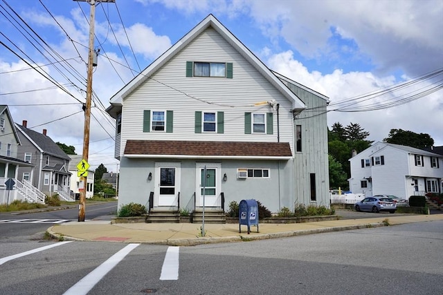 townhome / multi-family property featuring a shingled roof, entry steps, and stucco siding