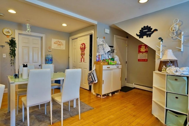 dining room with light wood-style floors, baseboards, baseboard heating, and recessed lighting