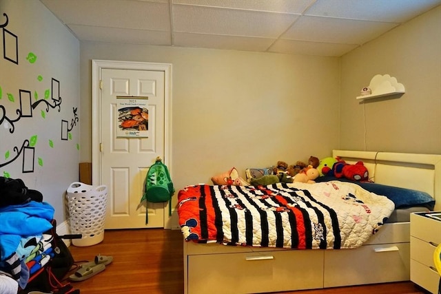 bedroom featuring a paneled ceiling and wood finished floors