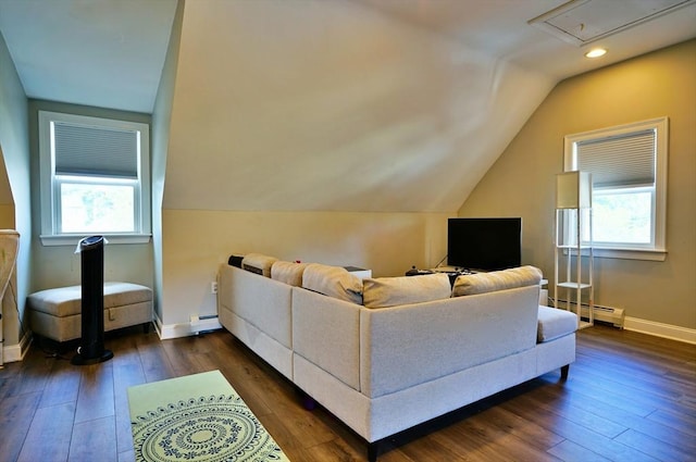 living room with a baseboard heating unit, dark wood-style flooring, a wealth of natural light, and baseboards