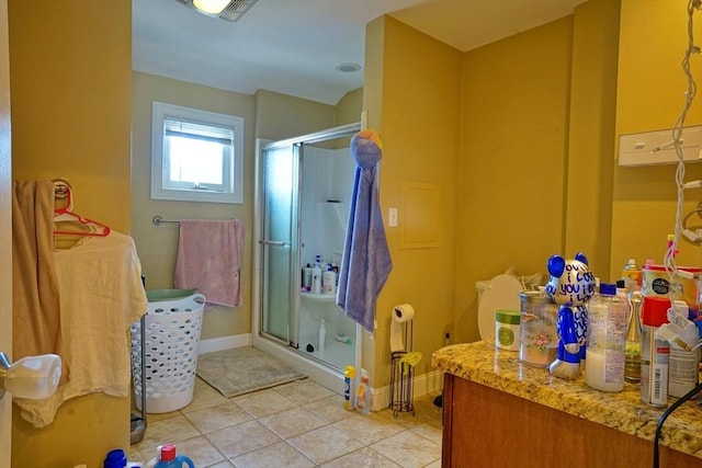 full bathroom featuring a stall shower, tile patterned flooring, and baseboards