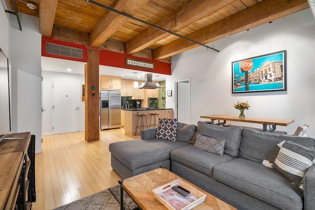 living room with light wood-type flooring, beam ceiling, wooden ceiling, and visible vents