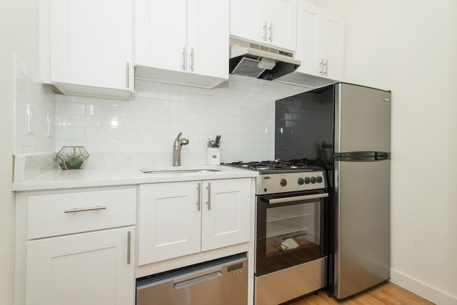148-150 Pleasant St, Boston, MA 02125 - kitchen featuring stainless steel appliances, under cabinet range hood, backsplash, white cabinets, and light countertops