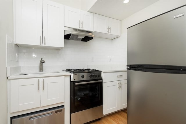 148-150 Pleasant St, Boston, MA 02125 - kitchen featuring appliances with stainless steel finishes, under cabinet range hood, light countertops, and white cabinetry