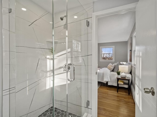 bathroom featuring wood-type flooring and a shower with shower door