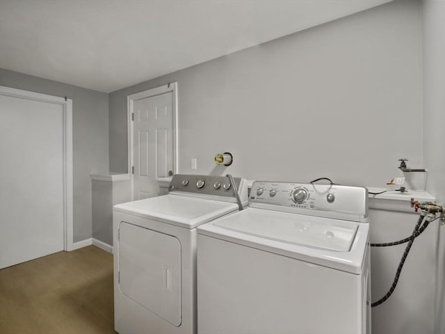 clothes washing area featuring separate washer and dryer and hardwood / wood-style floors