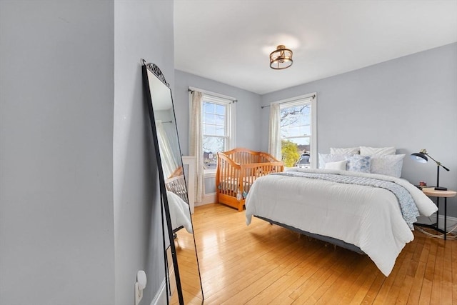 bedroom with baseboards and light wood finished floors