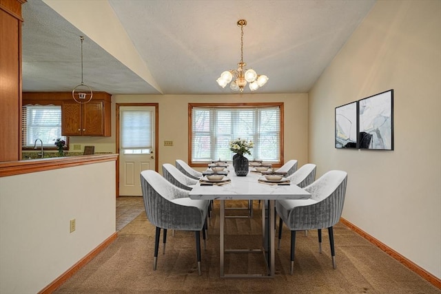 dining room with an inviting chandelier, carpet flooring, and vaulted ceiling
