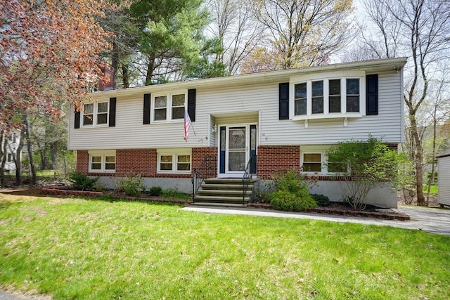 raised ranch with brick siding and a front lawn