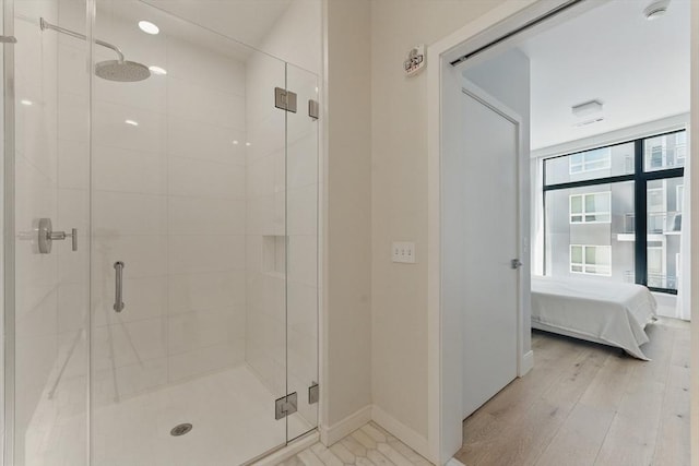 191 Washington St Unit 524, Boston, MA 02135 - bathroom with a shower stall, baseboards, ensuite bath, and wood finished floors